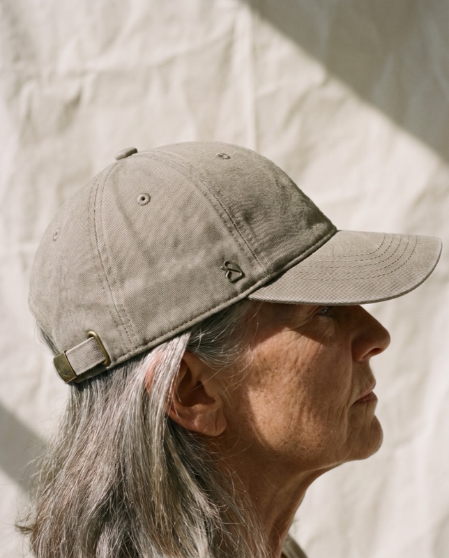 A woman in a stone twill cap seen in profile